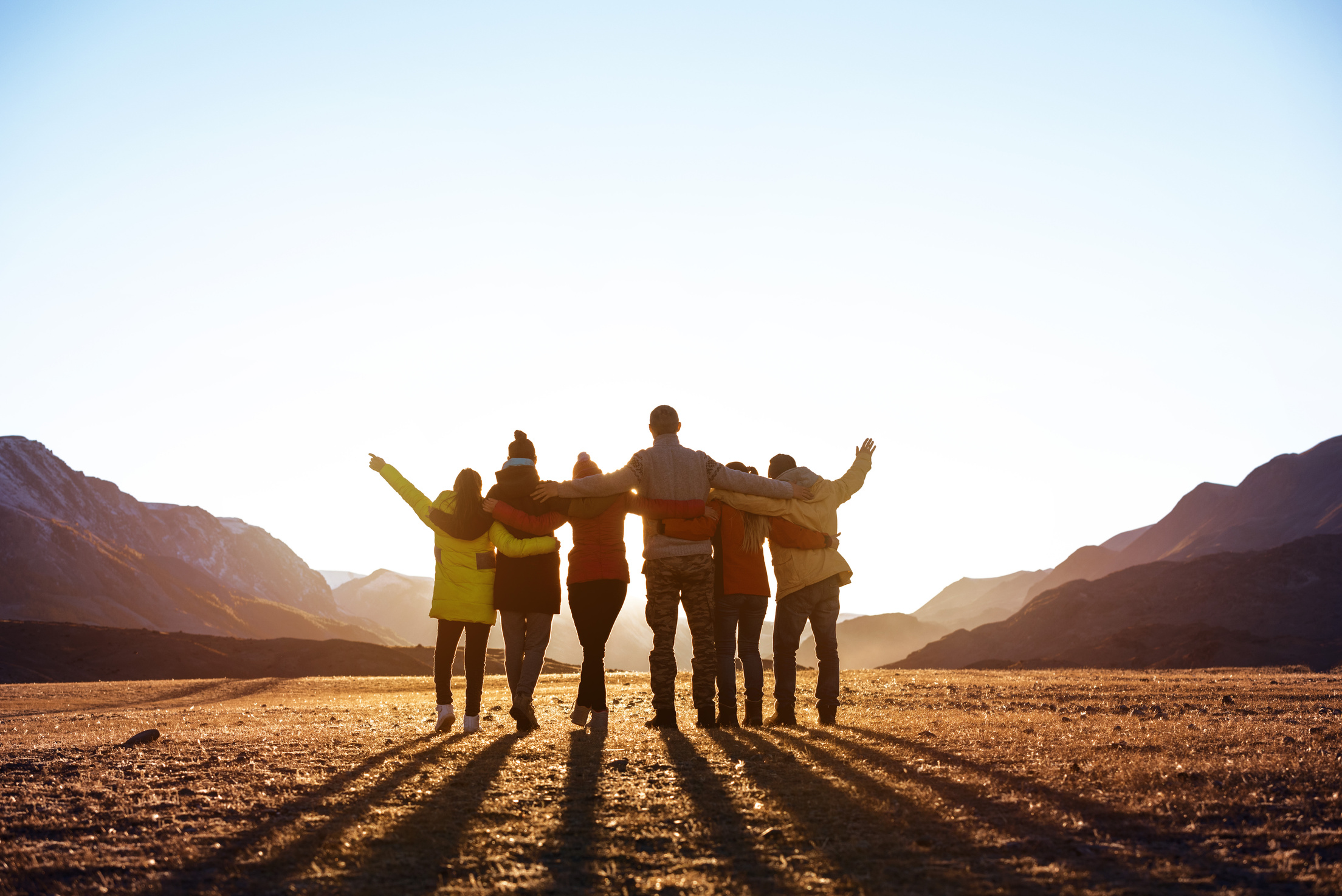 Group of friends against sunset mountains